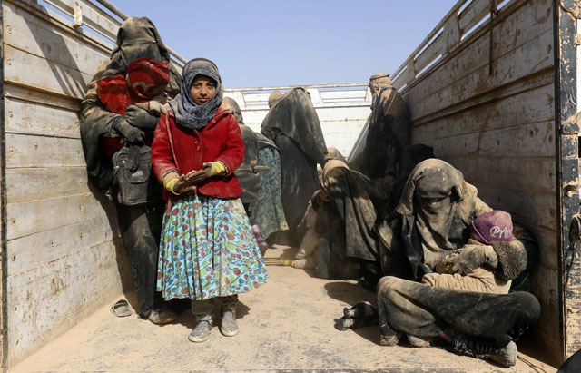 People, who fled battles between Syrian Democratic Forces (SDF) and terrorists from the Daesh group in the Syrian village of Baghouz, arrive after crossing a desert in the back of a truck to a region controlled by the SDF in the countryside of the Deir Ezzor province on Saturday (AFP photo) 