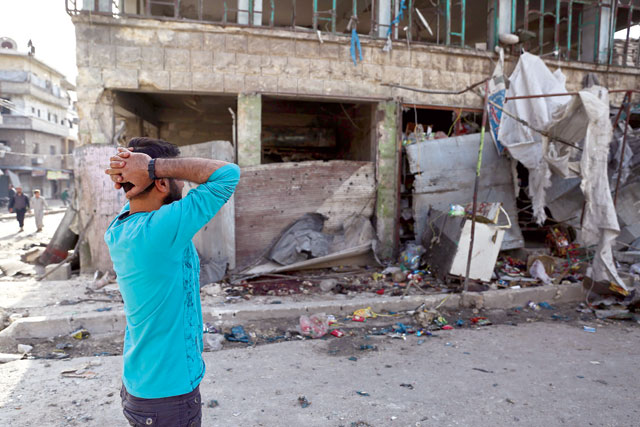 People gather at the site of an air strike on a market in the town of Maarat Al Numan on Wednesday (AFP photo)