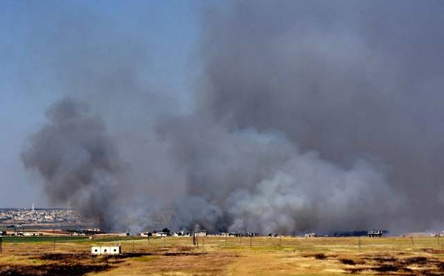 Smoke billows above buildings in the town of Kafr Nabuda in the north of the Syrian Hama province during reported air strikes by Syrian regime forces on Sunday  (AFP photo)
