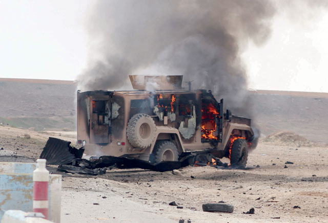 A military vehicle is on fire at the scene of a suicide car bomb attack on a military convoy on a road in Syria's northeastern Hasakeh province, which killed five members of a Kurdish-led force accompanying US-led coalition troops, on Monday (AFP photo)