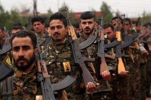 Fighters from the Syrian Democratic Forces (SDF) attend the funeral of a local official that the SDF say was assassinated in a Kurdish-held area in the countryside of Deir Ezzor, in the Syrian Kurdish-majority city of Qamishli, on Monday (AFP photo)