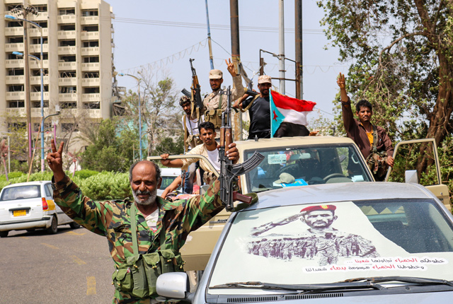   Fighters of the UAE-trained Security Belt force flash the victory gesture sign with a southern separatist flag (the old flag of South Yemen) in the back of a pickup truck in the Khor Maksar district of the second city of Aden on Thursday (AFP photo)