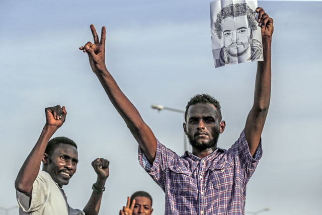   A Sudanese protester raises a picture of a fellow demonstrator, killed last month in a brutal raid on a Khartoum sit-in, during a rally in the capital Khartoum to mourn their death, on Saturday (AFP photo)