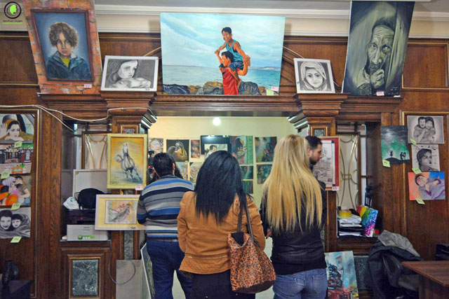 Visitors examine artwork by Syrian refugees on display at ‘Souriyat across borders’ in Amman recently (Photo courtesy of ‘Souriyat across borders’)
