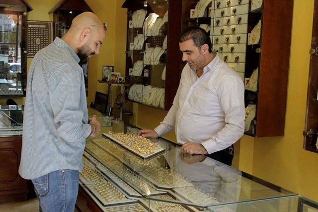 A customer examines jewellery at a shop in Amman on Saturday (Photo by Osama Aqarbeh)
