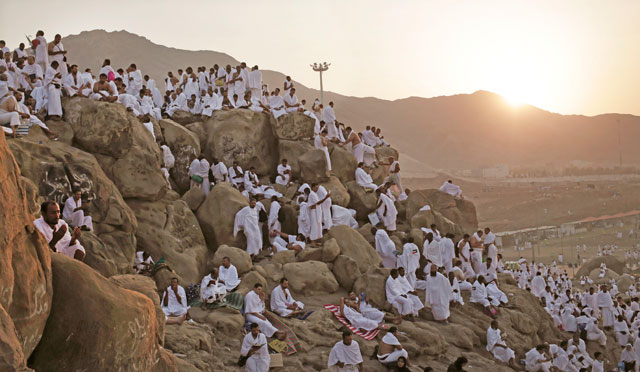Muslim pilgrims pray on a rocky hill known as Mountain of Mercy, on the Plain of Arafat, during the annual Hajj, ahead of sunrise near the holy city of Mecca, Saudi Arabia, on Sunday (AP photo)