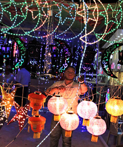 A vendor arranges illuminated crescents and lanterns in Amman this week. Sales of these products rise ahead of the fasting month of Ramadan (Photo by Osama Aqarbeh)