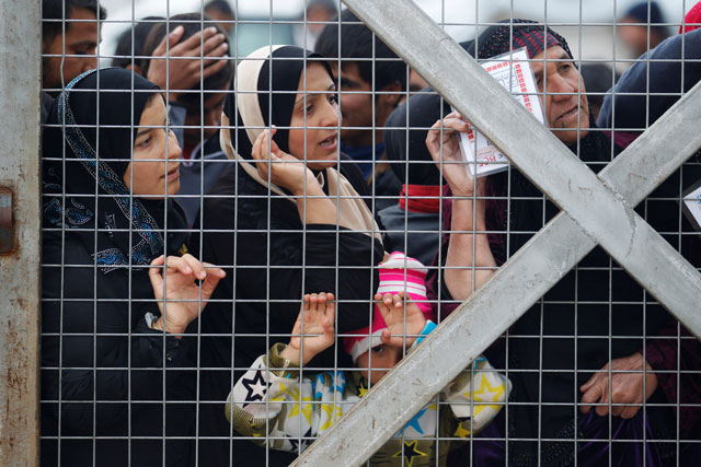 Displaced women, who fled the Daesh stronghold of Mosul, stand behind the fence to receive aid at Hassan Sham camp, east of Mosul, Iraq, on Tuesday (Reuters photo by Khalid Al Mousily)