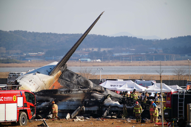 Rescue personnel work near the tail section of a Jeju Air Boeing 737-800 series aircraft after the plane crashed and burst into flames at Muan International Airport in South Jeolla Province, some 288 kilometres southwest of Seoul on December 29, 2024 (AFP photo)