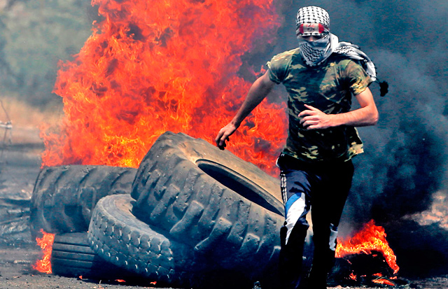   A Palestinian protester runs for cover while being chased by Israeli forces during a weekly demonstration against the expropriation of Palestinian lands by Israel in the village of Kfar Qaddum, near Nablus in the occupied West Bank, on Friday (AFP photo)