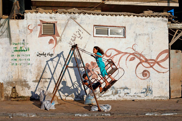 Palestinian children play on a swing at Al Shatee refugee camp in Gaza City on Wednesday (AFP photo)