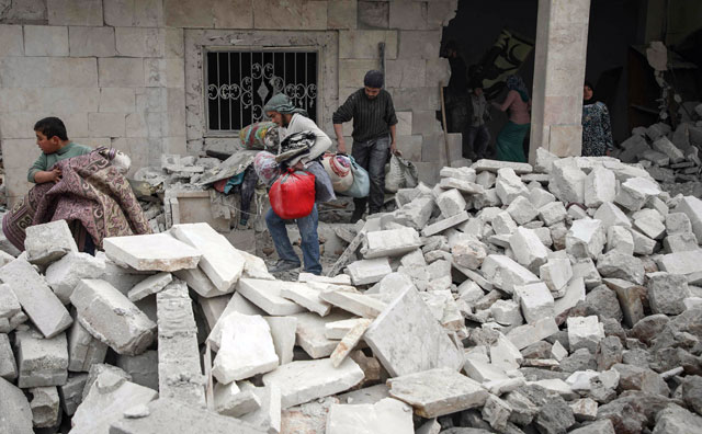 Syrians salvage items from a building which was damaged by a reported air strike in the rebel-held town of Orum Al Kubra, in the northern Syrian province of Aleppo, on Saturday (AFP photo)