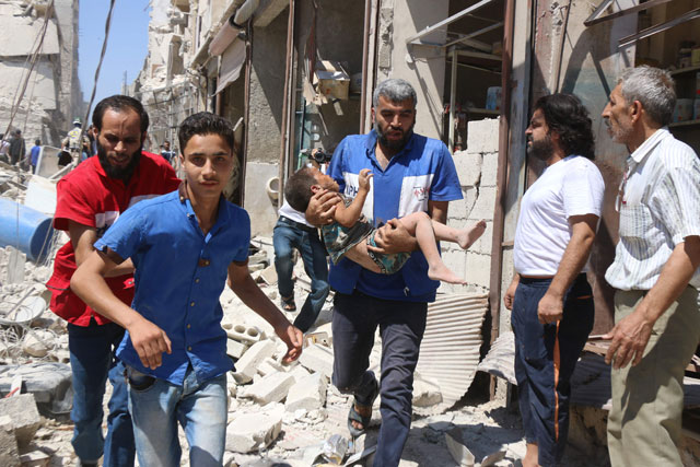 A Syrian civil defence volunteer carries a wounded child following a reported air strike on the rebel-held neighbourhood of Qatirji in the northern city of Aleppo on Sunday (AFP photo)