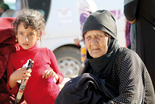 Syrians wait to get on buses, headed towards temporary refugee centres in Idlib, following the arrival of first evacuation convoy of 40 buses transporting 500 people arrived in Hama after a deal struck between Assad regime and opposition forces, on Friday, in Quneitra (Anadolu Agency photo)