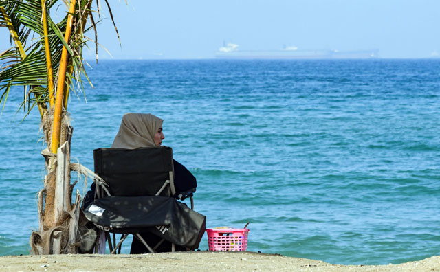   A woman sits along a beach in the eastern UAE emirate of Fujairah on Saturday (AFP photo)