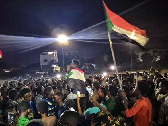   Sudanese demonstrators wave national flags as they protest in the streets of the capital Khartoum to demand civilian rule on Monday (AFP photo)