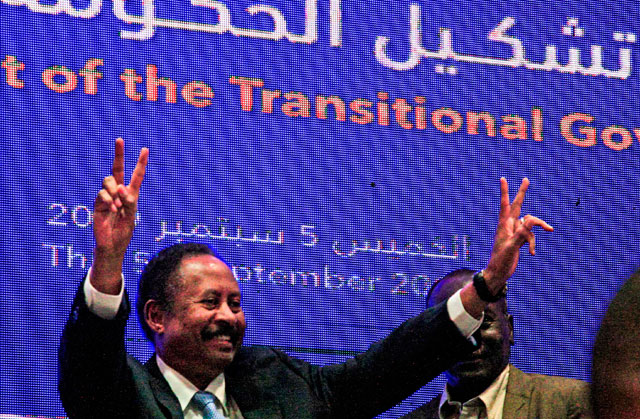   Sudan's new Prime Minister Abdalla Hamdok flashes the victory gesture during a press conference unveiling the first Cabinet since veteran leader Omar Al Bashir's overthrow in the capital Khartoum on Thursday (AFP photo)