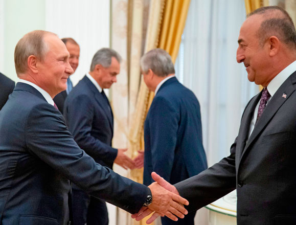 Russian President Vladimir Putin (left) shakes hands with Turkish Foreign Minister Mevlut Cavusoglu, prior to their meeting at the Kremlin in Moscow, on Friday (AFP photo)