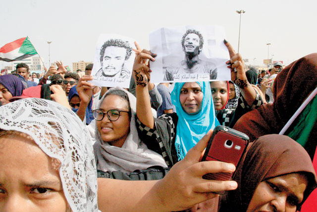 Sudanese protesters hold posters bearing the portrait of one of the victims in the capital Khartoum's Green Square on July 18 (AFP photo)