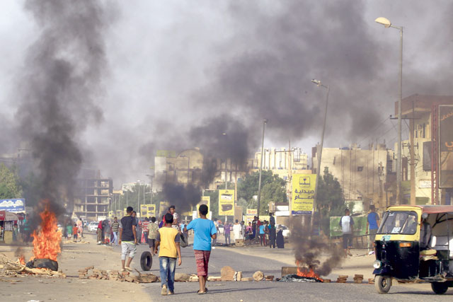 Demonstrators burn tyres in the middle of a main street in Khartoum on Saturday, as they protest against the results of the probe into the June raid on a Khartoum protest camp  (AFP photo)