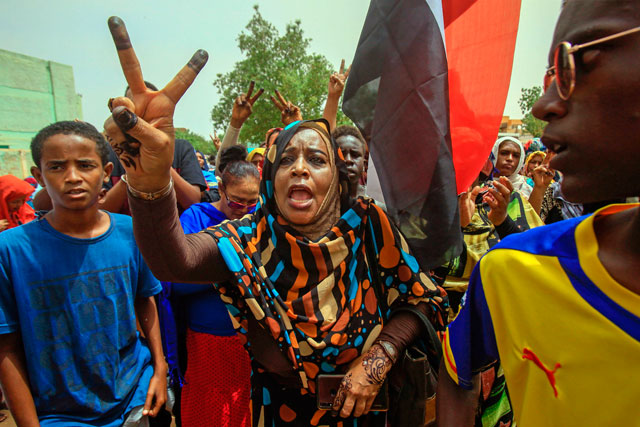   Sudanese protesters flash the V-sign during a mass demonstration against Sudan's ruling  generals in Khartoum on Sunday (AFP photo)