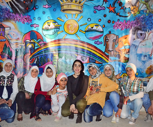 In this undated photo, refugee children who drew the combined mural can be seen posing for a group picture (Photo by Yasmeen Kanaan)