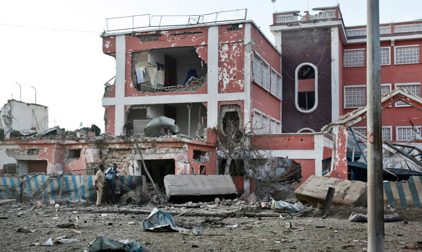A Somali policeman walks through the scene of destruction outside the Sahafi Hotel in Mogadishu, on Sunday (AP photo)