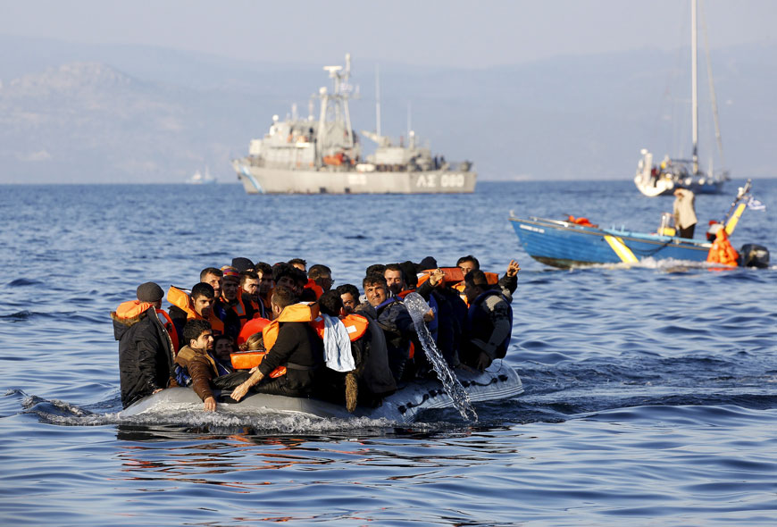 A man empties water from a flooding raft overcrowded by Syrian refugees that approaches a beach at the Greek island of Lesbos, Thursday (Reuters photo)