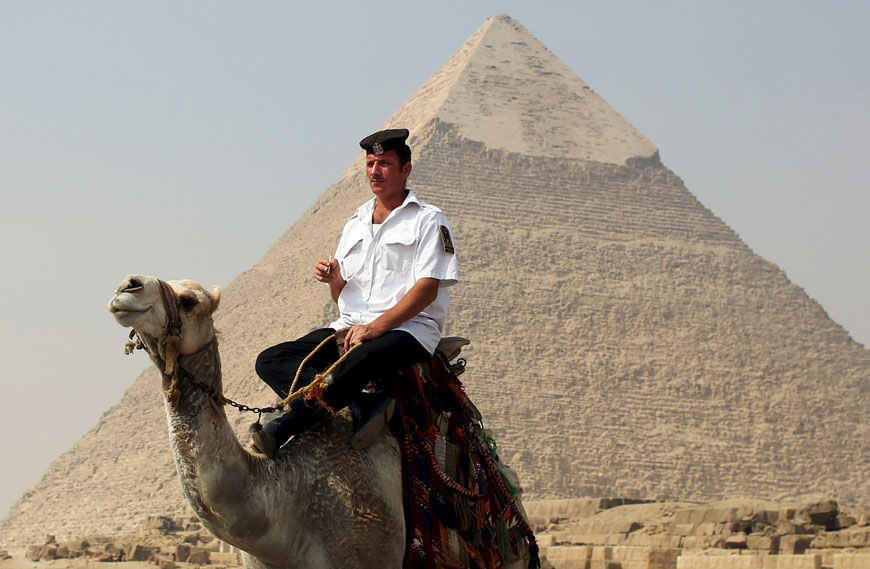 A policeman rides a camel while guarding the site of the pyramids plateau on Thursday (Reuters photo)