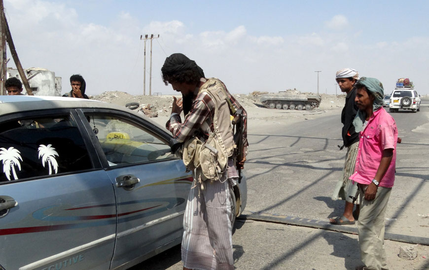 Members of the pro-government Popular Committees militia inspect a car at a checkpoint on a road leading to Yemen’s southern province of Abyan on Wednesday (Reuters photo)