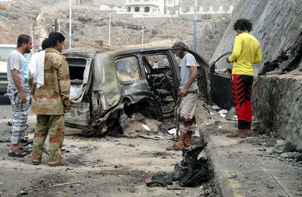 People look at the wreckage of a car at the site of a car bomb attack that killed the governor of Yemen’s southern port city of Aden on Sunday (Reuters photo)