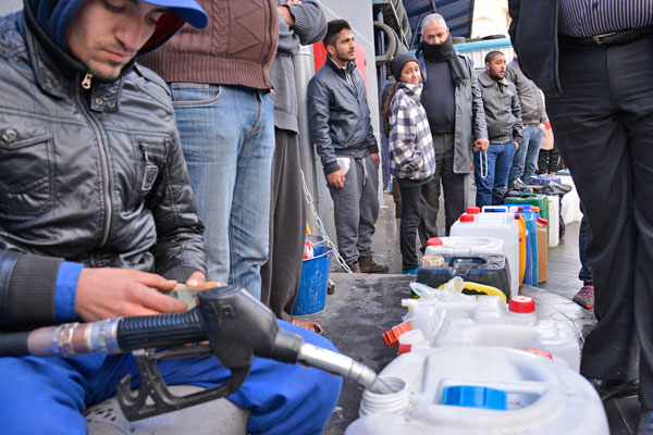 A gas station worker fills kerosene gallons for queued customers in Amman on Thursday (Photo by Amjad Ghsoun)