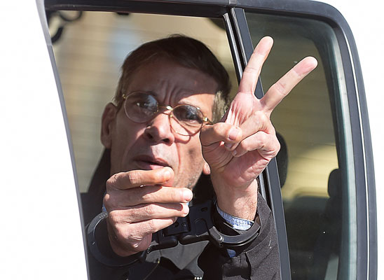 Handcuffed Seif Al Din Mohamed Mostafa, an Egyptian man who hijacked an EgyptAir passenger plane the previous day and forced it to divert to Cyprus flashes the ‘V’ for victory sign as he leaves the court in Larnaca in a police car on Wednesday (AFP photo)