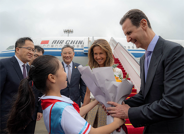A handout photo released by the official Syrian Arab News Agency shows Syria's President Bashar Assad and First Lady Asma Al Assad being welcomed upon their arrival at the airport in Beijing, on Thursday (AFP photo)