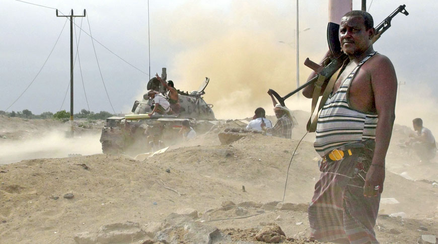 An anti-Houthi fighter of the Southern Popular Resistance stands guard as comrades fire from a tank in Yemen’s southern port city of Aden on Thursday (Reuters photo)