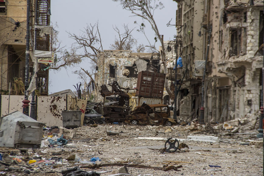 In this photo taken on March 24 damaged homes line in a street in Benghazi, Libya (AP photo)