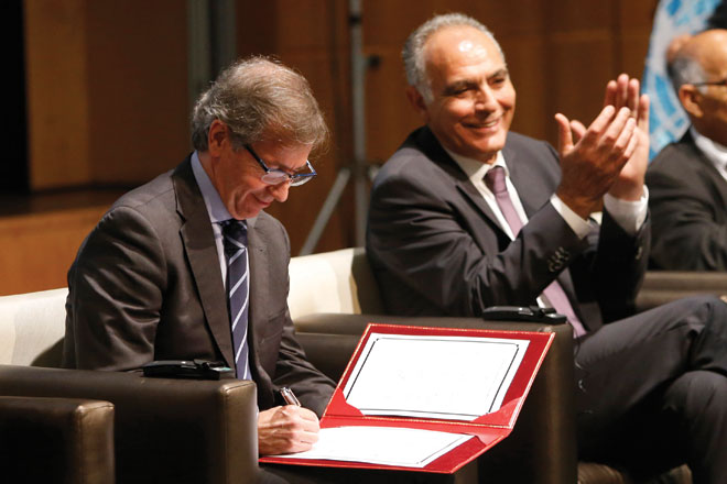 UN envoy to Libya Bernardino Leon (left) signs the document on a new version of a  UN-brokered peace deal as Morocco's Foreign Minister Salaheddine Mezouar applauds after Libyan political leaders agreed, at the Palais des Congres of Skhirate in Rabat, Morocco, on Saturday (AP photo)