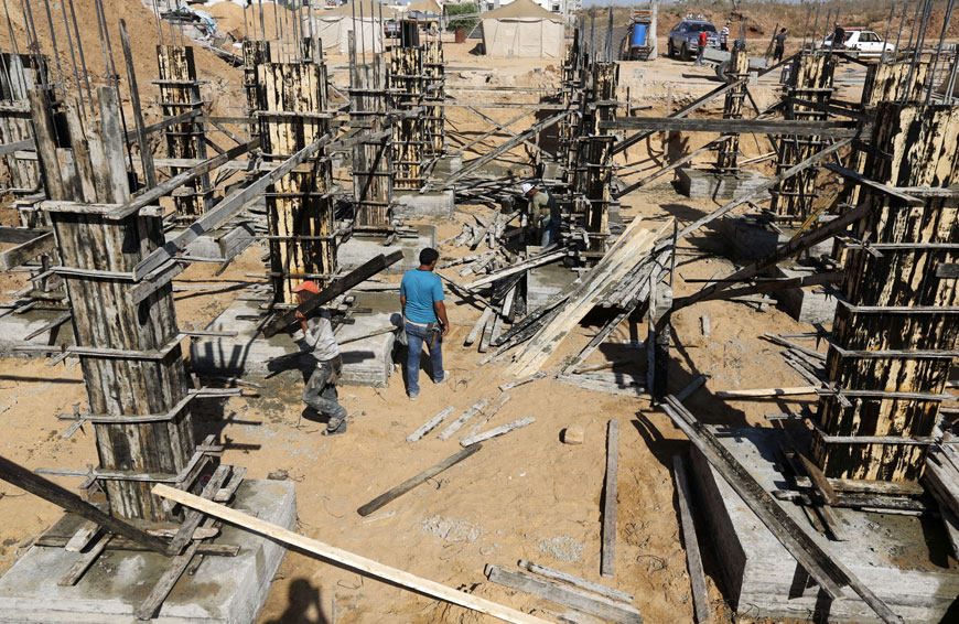 Palestinians work on a construction site to rebuild houses which were destroyed during the 50-day war between Israel and Hamas fighters in the summer of 2014 on Wednesday in Gaza City’s eastern suburb of Al Shejaiya (AFP photo)