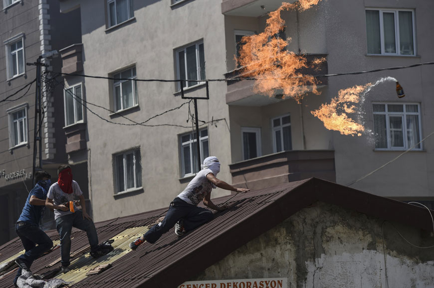 A left-wing militant throws a Molotov cocktail during clashes with Turkish riot police in Istanbul’s Gazi district (AFP photo)