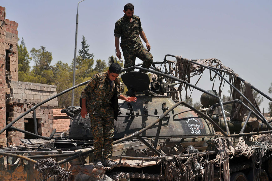 Members of the Kurdish People’s Protection Units stand on top a tank bearing Daesh militant logo in Al Nashwa neighbourhood in the northeastern Syrian province of Hasakeh on Sunday (AFP photo)