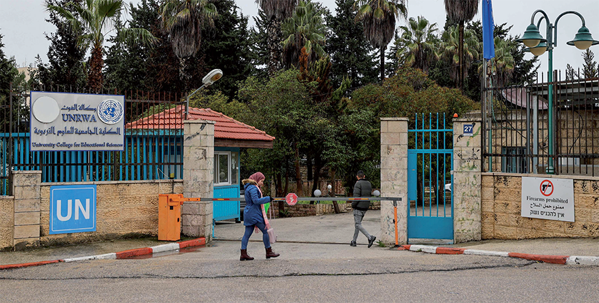 A Palestinian woman walks in front of the entrance of the UNRWA-run University College for Educational Science Ramallah city in the occupied West Bank on Monday (AFP photo)