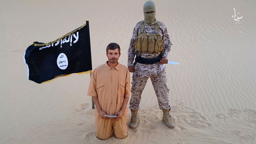 This image made from a militant video posted on a social media site on Wednesday, which has been verified and is consistent with other AP reporting, purports to show a militant standing next to another man who identifies himself as 30-year-old Tomislav Salopek, kneeling down as he reads a message at an unknown location (AP photo)