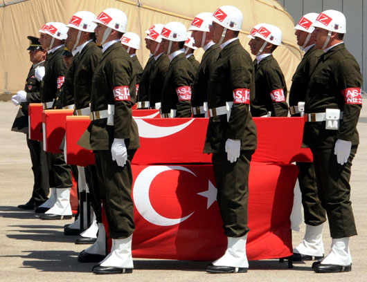 Turkish soldiers stand in attention next to the Turkish flag-draped coffins of three soldiers, killed in a roadside bomb attack by suspected Kurdish rebels, during a ceremony in the city of Van, southeastern Turkey, on Saturday (AP photo)