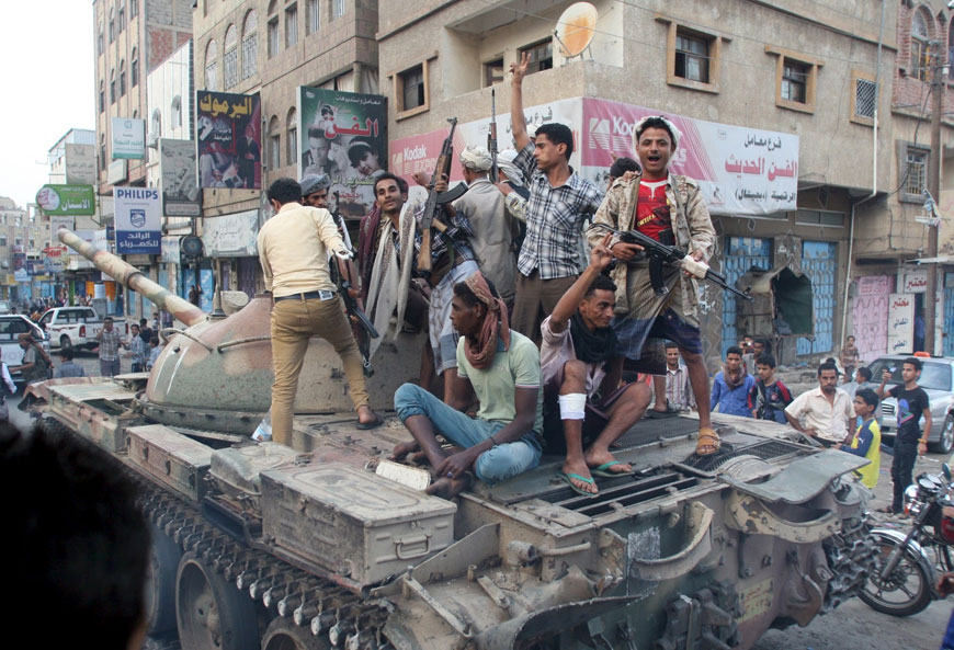 Militants loyal to Yemen’s exiled government ride atop a tank they seized from Houthi militiamen in the country’s central city of Taiz on Monday (Reuters photo)