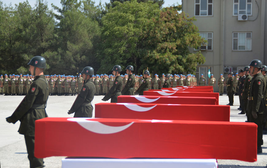 In this August 20 photo made available August 21, Turkish soldiers stand in attention next to the Turkish flag-draped coffins of eight Turkish soldiers, killed on a roadside bomb Wednesday, during a ceremony in Siirt, southeastern Turkey (AP photo)