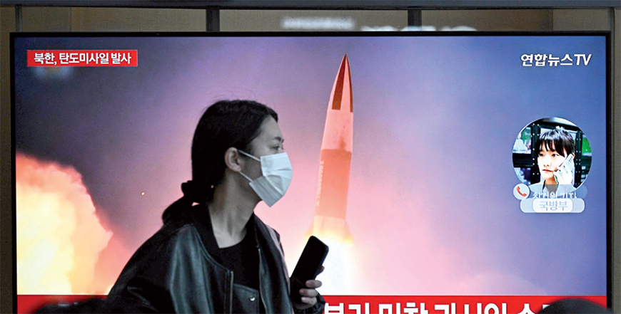 A woman walks past a television showing a news broadcast with file footage of a North Korean missile test, at a railway station in Seoul on Monday (AFP photo)