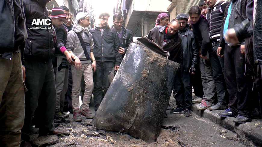 In this January 19, 2014 file photo, provided by Aleppo Media Centre, an anti-Bashar Assad activist group, which has been authenticated based on its contents and other AP reporting, Syrian citizens inspect an unexploded barrel of explosives which was dropped from a Syrian forces helicopter, on a street in Aleppo, Syria (AP photo/Aleppo Media Centre)