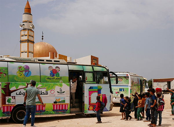 A photo taken on May 23 shows children getting ready to board a bus turned into a travelling classroom reaching children left homeless and school-less at a camp for internally displaced persons (IDP) in Jindayris in the rebel-held northwestern Syrian province of Aleppo (AFP photo)