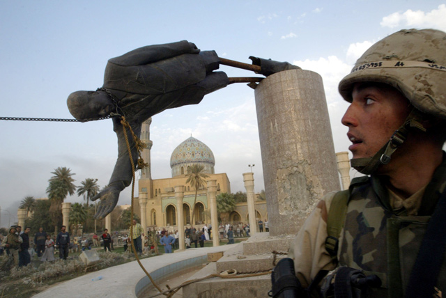 A US soldier watches as a statue of Iraq's President Saddam Hussein falls in central Baghdad, Iraq, on April 9, 2003 (Reuters file photo)