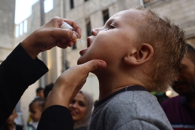 A medic administers a polio vaccine to a Palestinian child in Khan Yunis in the southern Gaza Strip on October 19, 2024 (AFP photo)